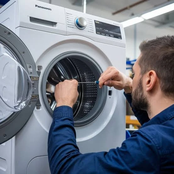 Technician examining the drum of a front-loading washing machine